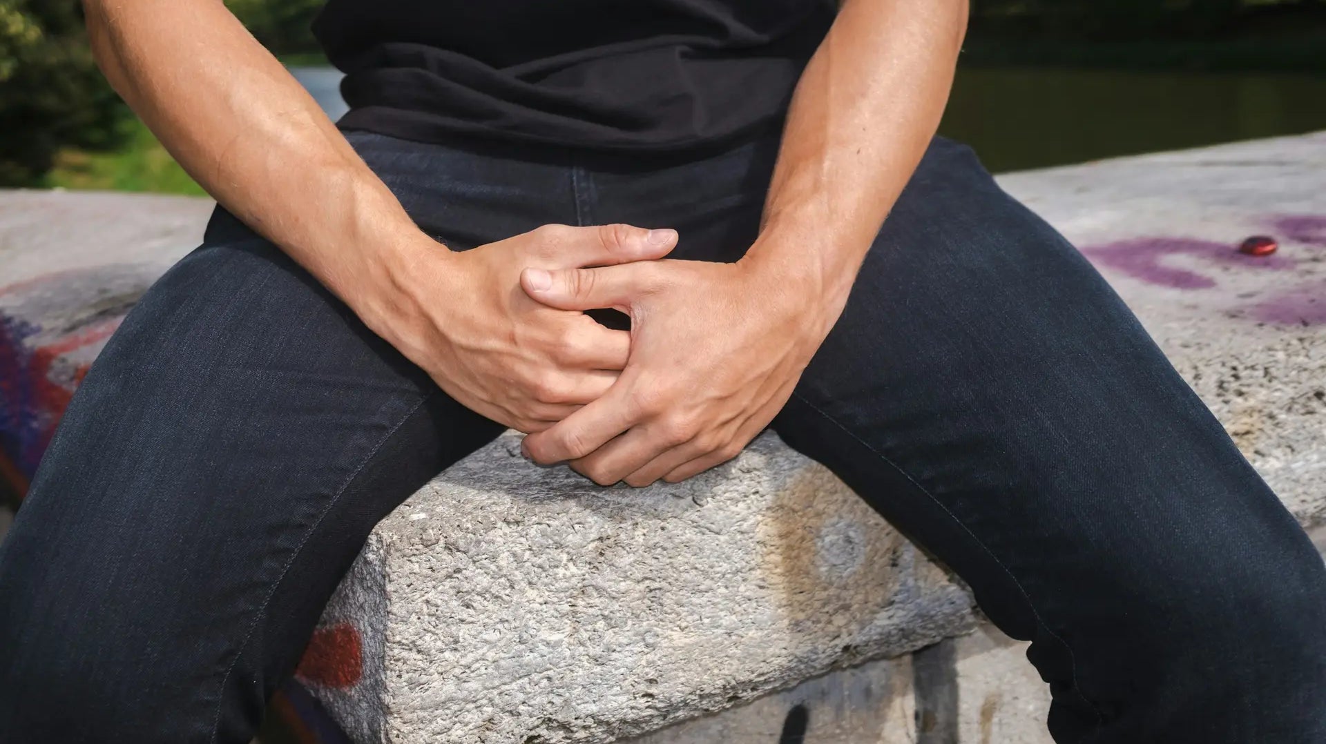 Man sitting with hands clasped, reflecting discomfort associated with shy bladder syndrome — photo by Filipp Romanovski