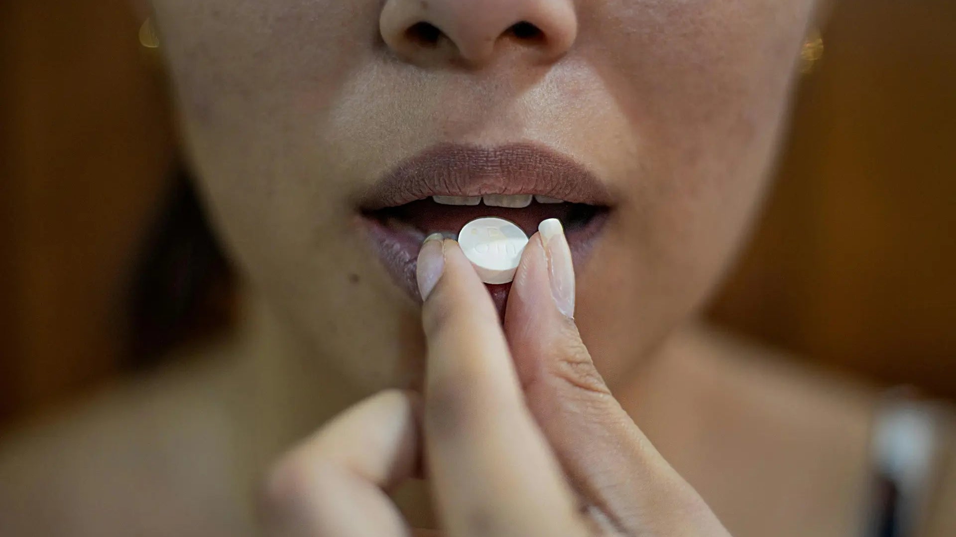 Person taking a tablet, representing acne medication and its side effects — photo by Danilo Alvesd