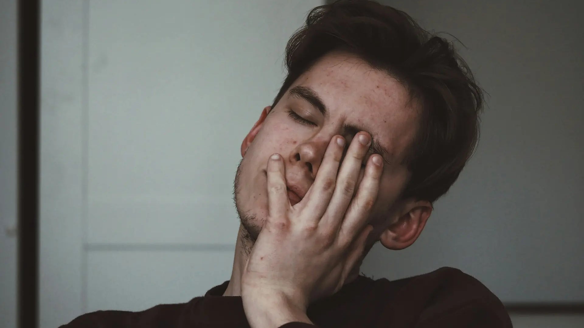 Man rubbing his tired eyes, reflecting fatigue linked to low immunity — photo by Adrian Swancar