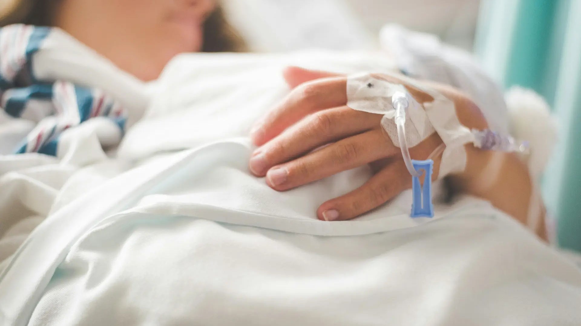Close-up of a patient's hand resting during hospital treatment, reflecting the experience of chemotherapy — photo by Stephen Andrews