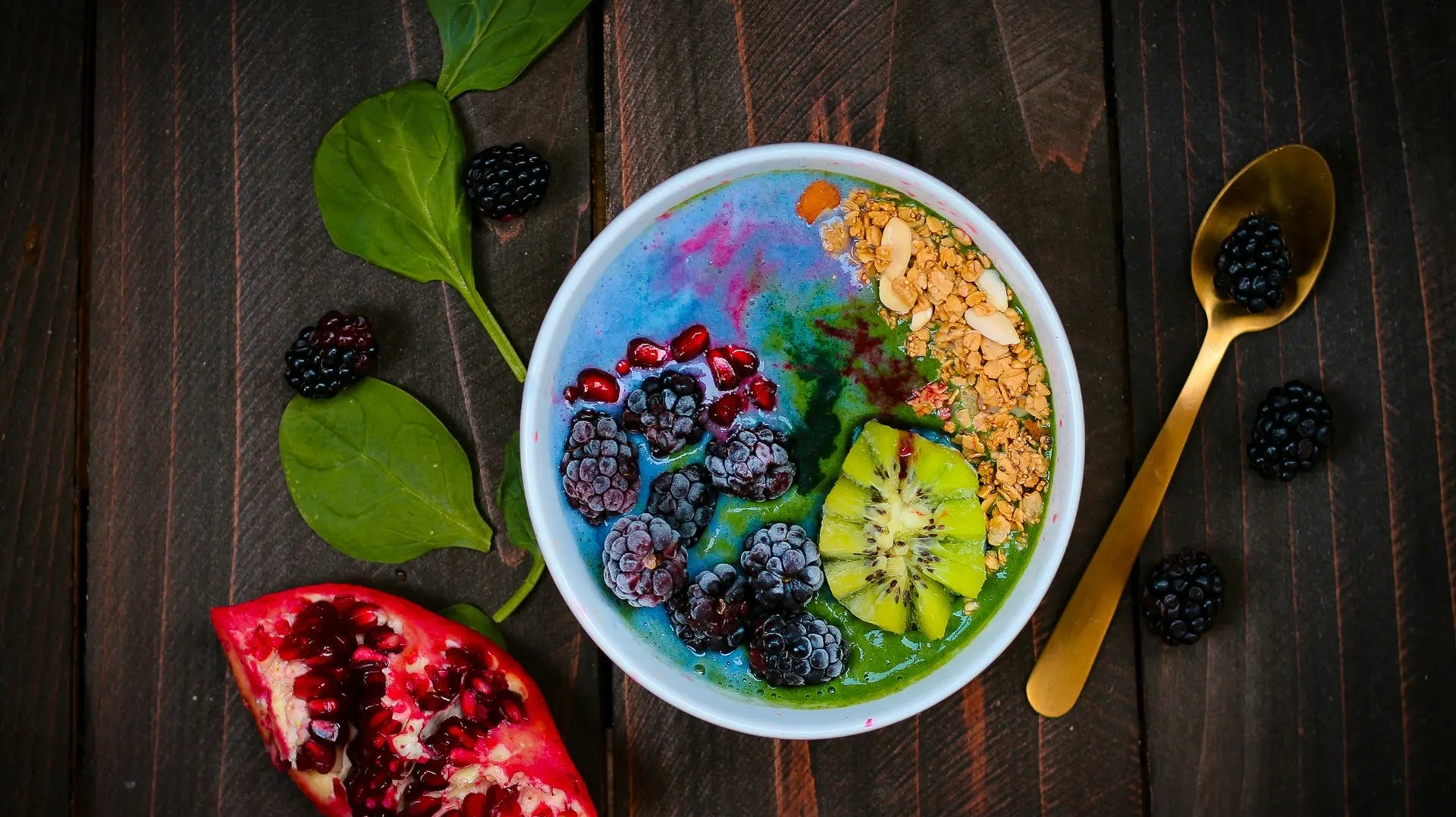 Blue spirulina smoothie bowl topped with blackberries, pomegranate, kiwi, and granola — photo by Kimzy Nanney