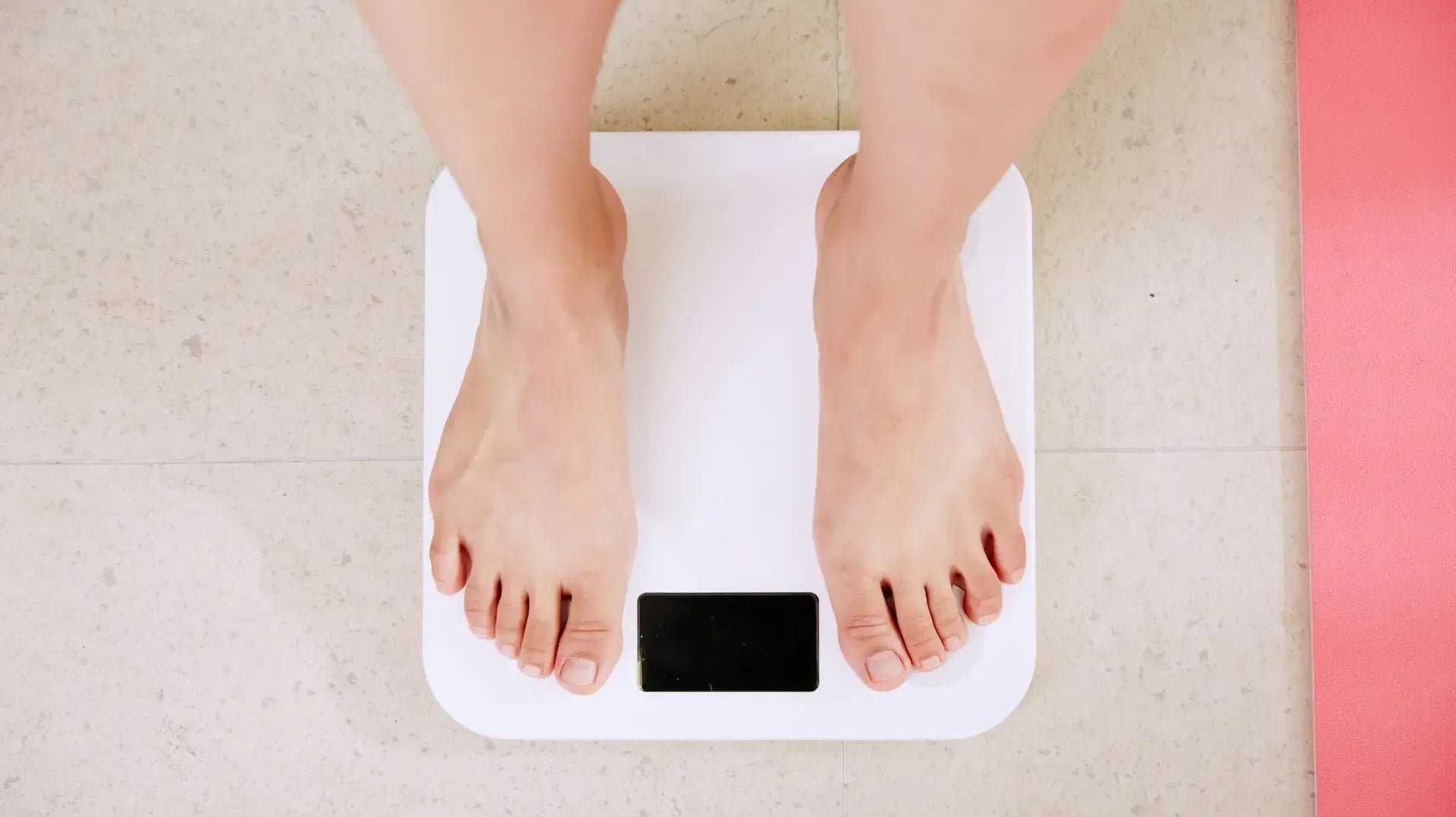 Feet standing on a bathroom scale, reflecting weight and health concerns — photo by i yunmai