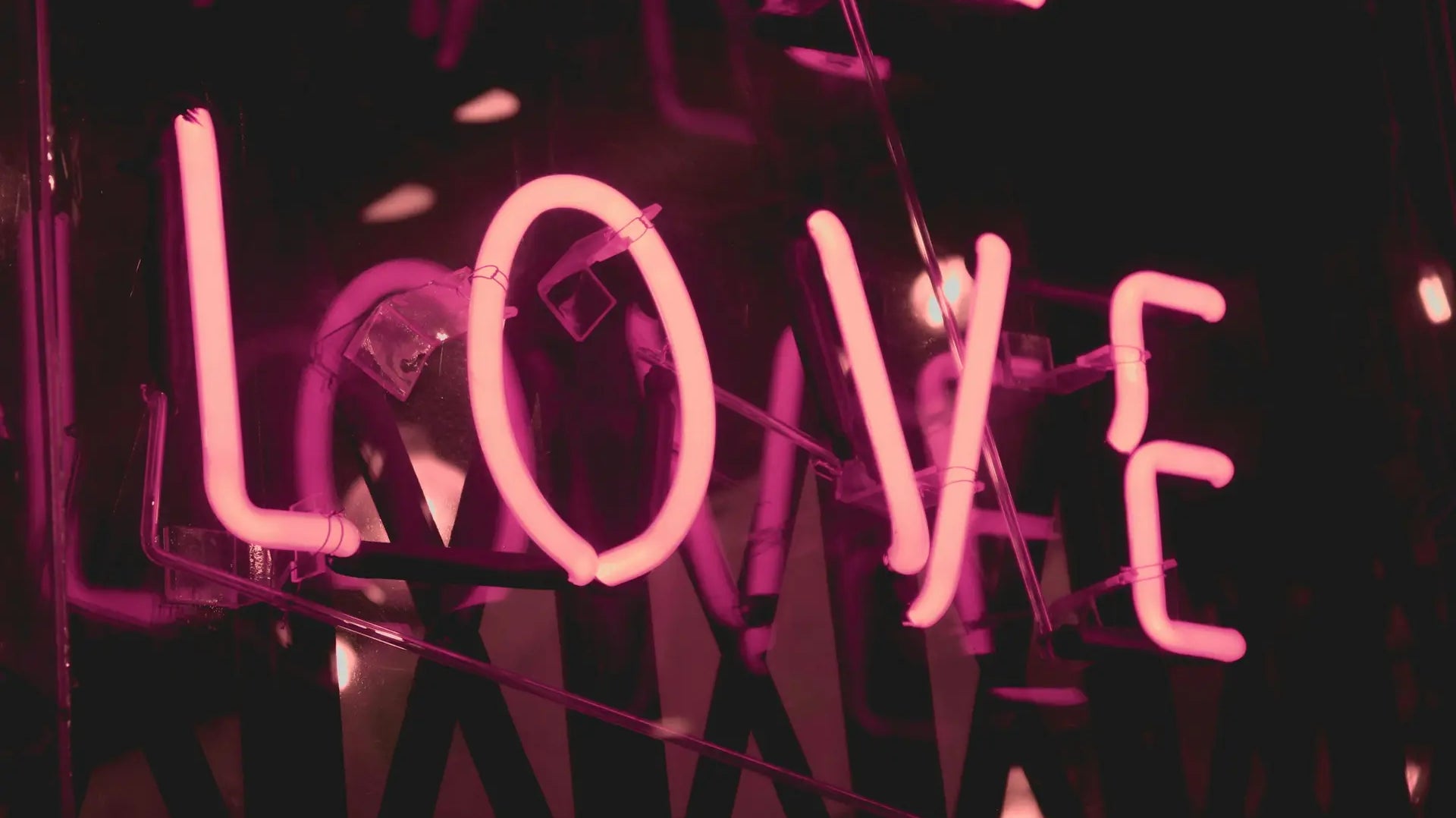 Pink neon LOVE sign representing oxytocin, the love hormone — photo by Shaira Dela Peña