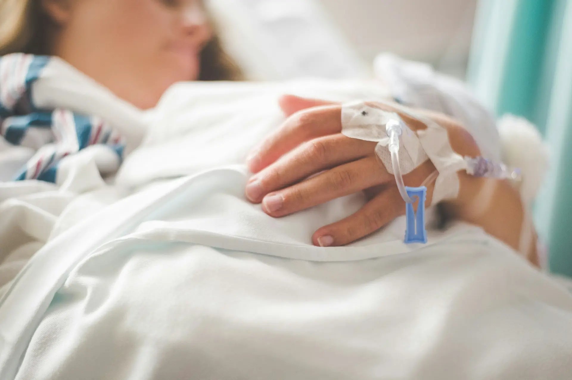 Close-up of a patient's hand resting during hospital treatment, reflecting the experience of chemotherapy — photo by Stephen Andrews