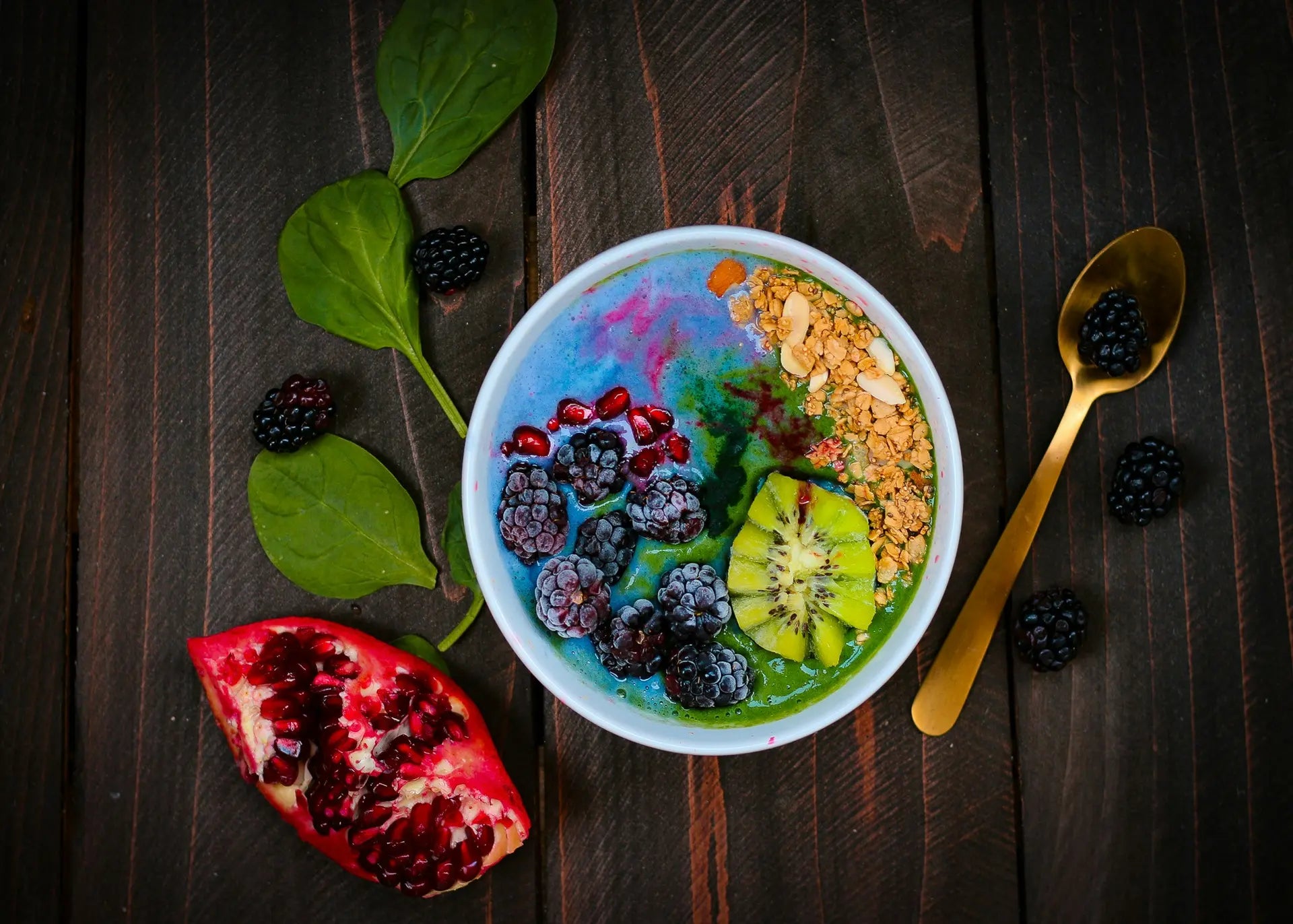 Blue spirulina smoothie bowl topped with blackberries, pomegranate, kiwi, and granola — photo by Kimzy Nanney