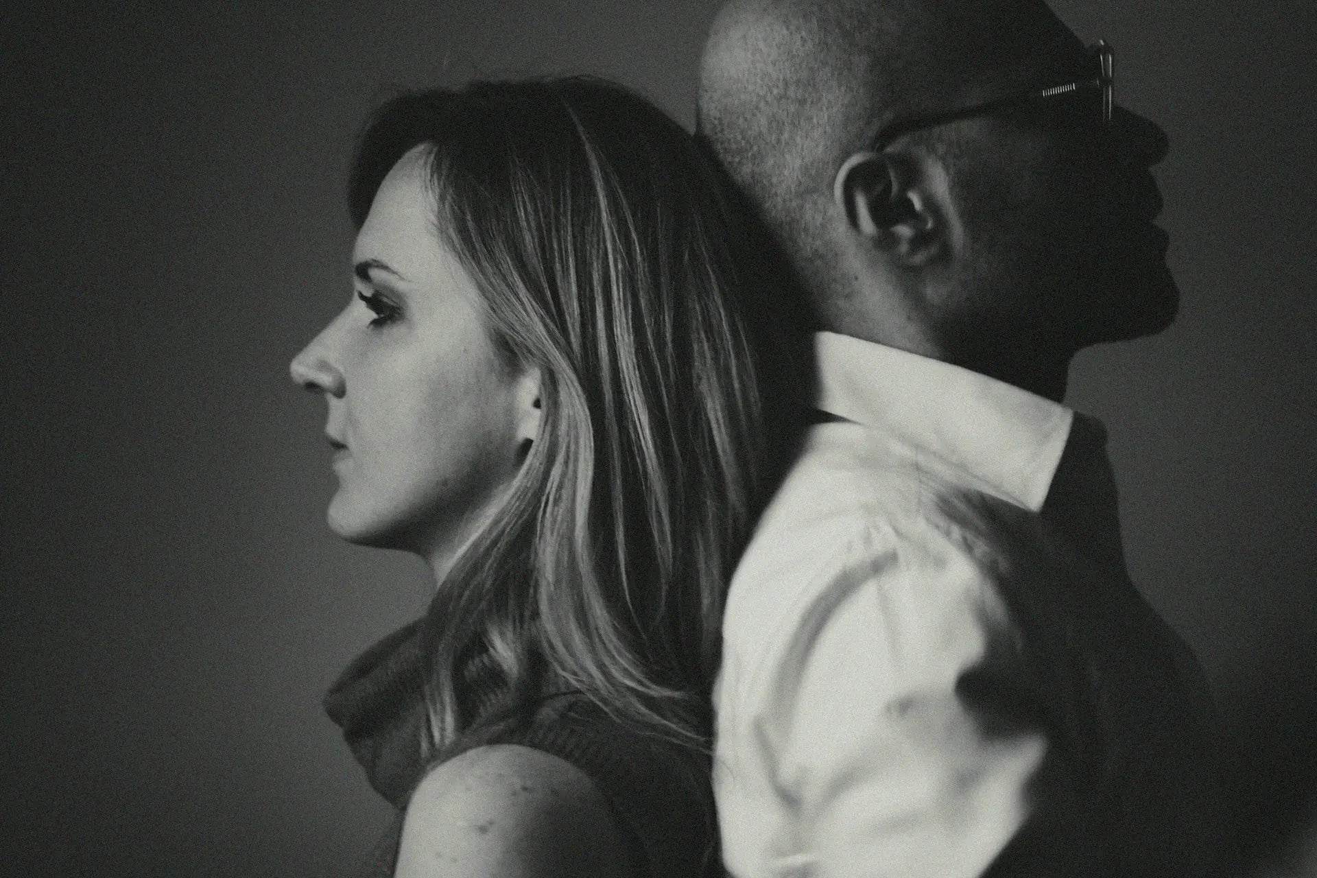 Couple standing back to back, reflecting emotional distance that sex therapy can help address — photo by Alex Sheldon