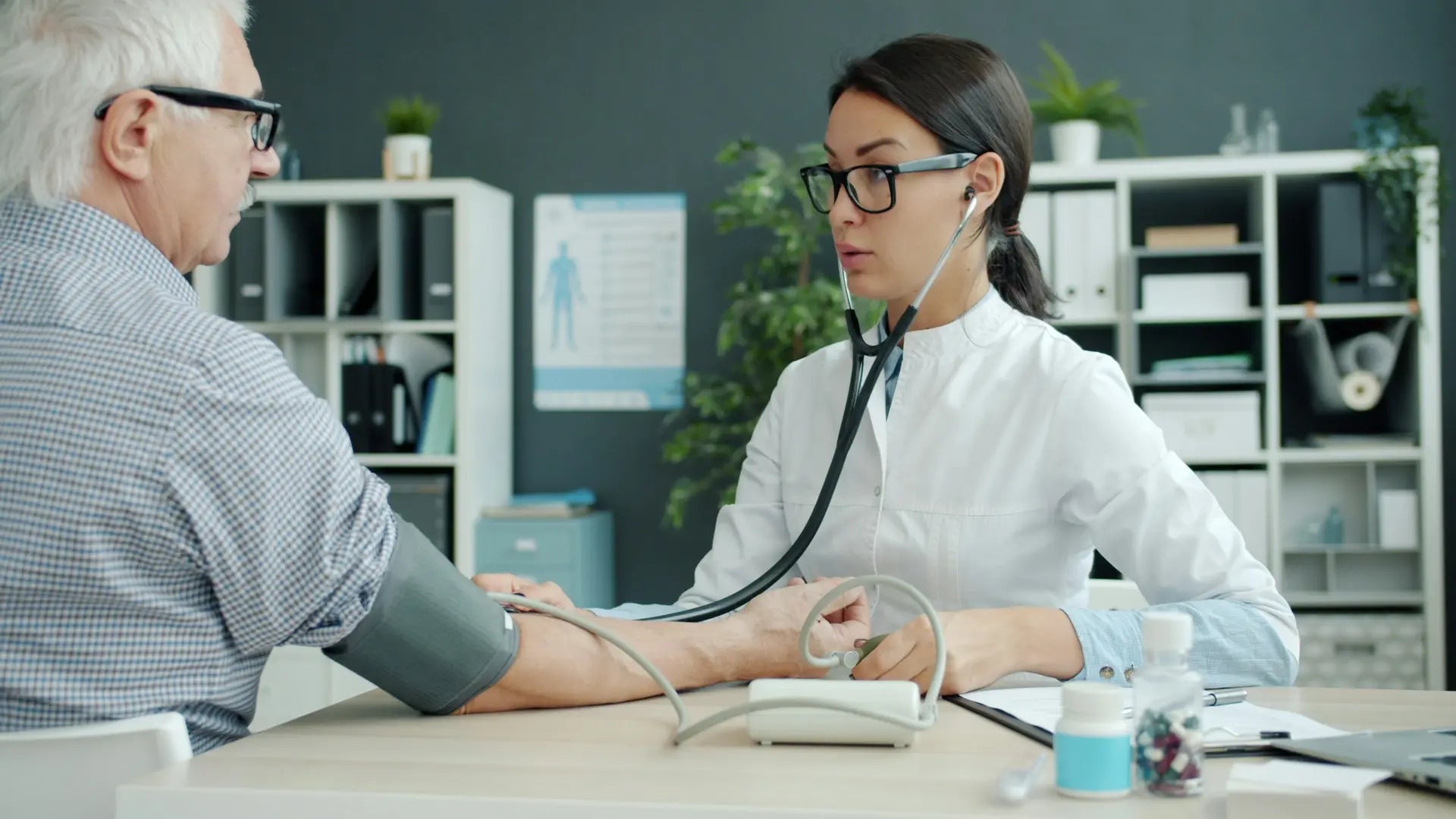 Doctor checking an older patient's blood pressure during a consultation — photo by Vitaly Gariev