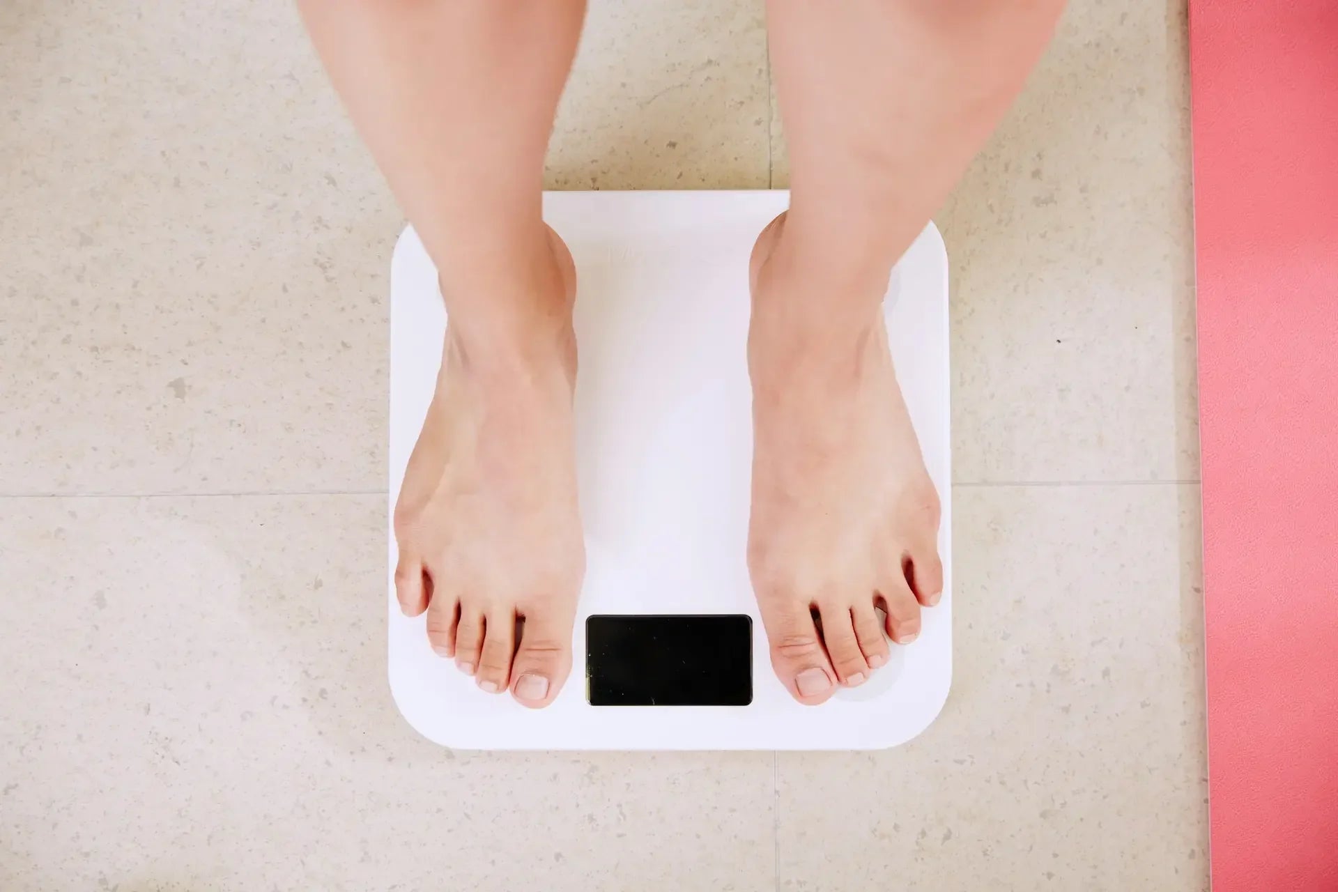 Feet standing on a bathroom scale, reflecting weight and health concerns — photo by i yunmai