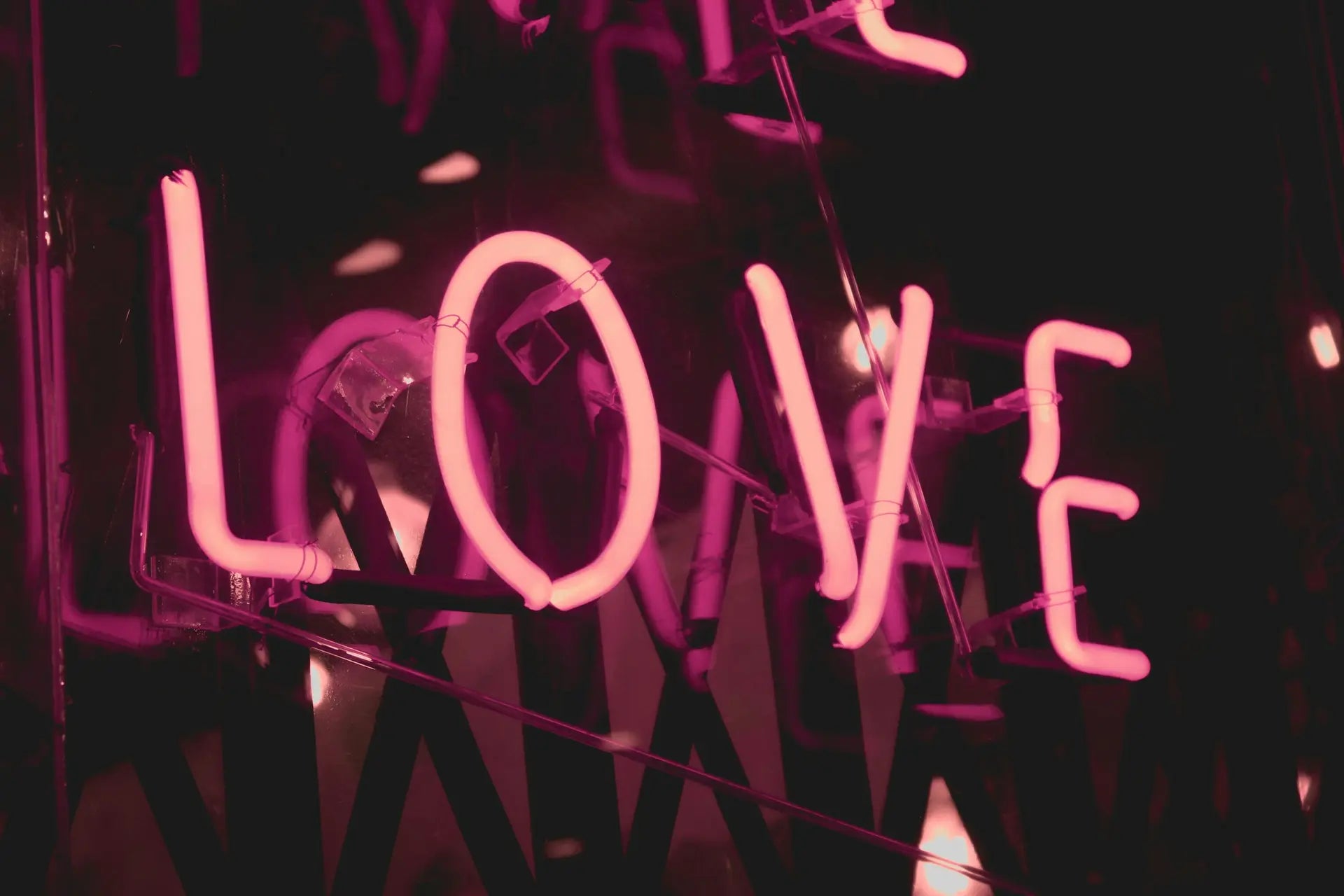Pink neon LOVE sign representing oxytocin, the love hormone — photo by Shaira Dela Peña